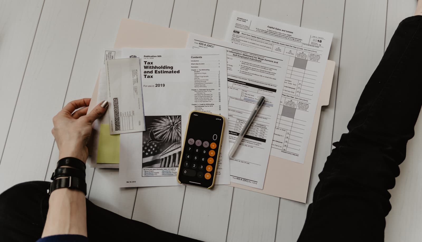 Tax forms, a calculator and a phone on a desk