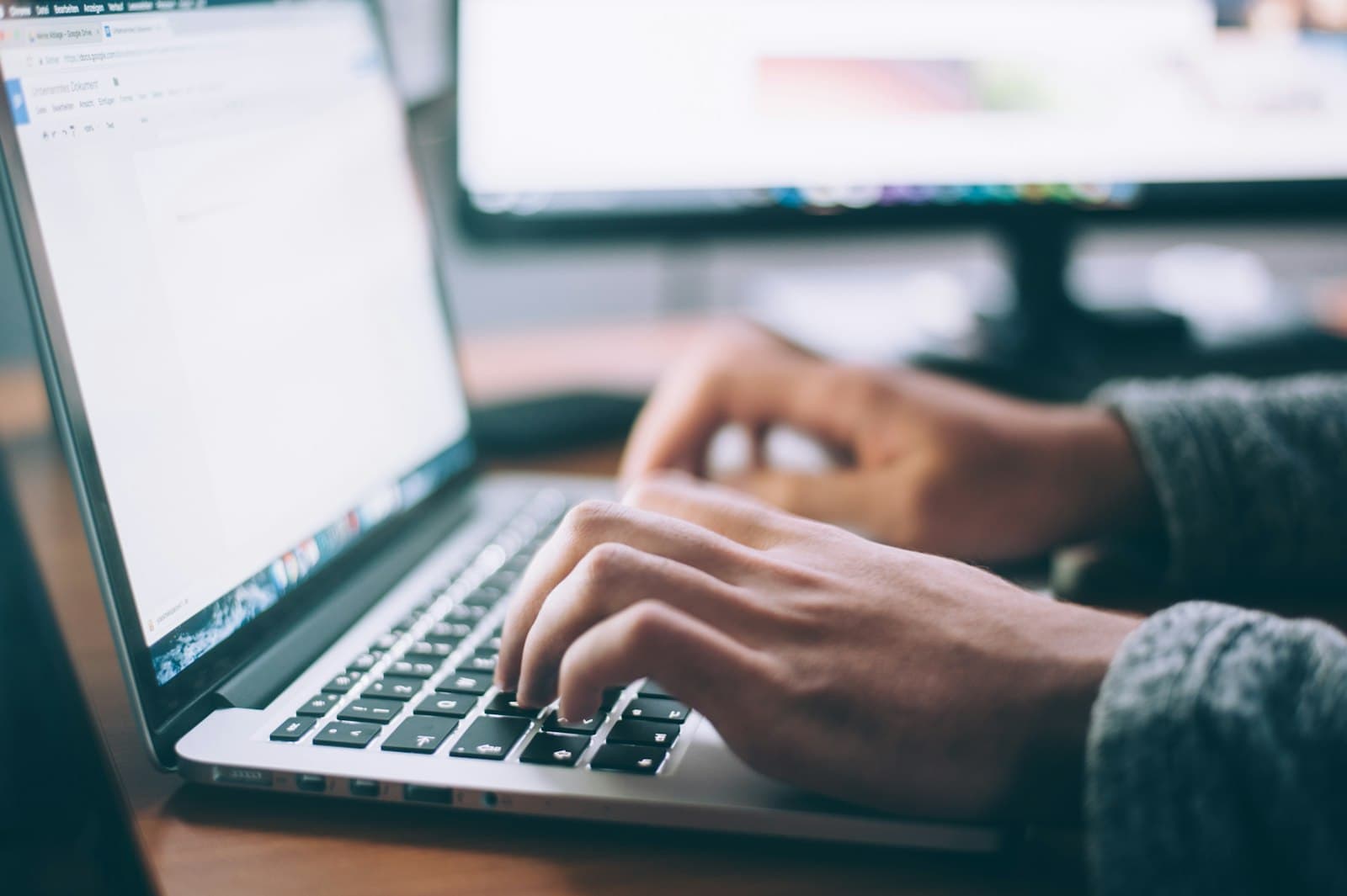 Hände tippen konzentriert auf einer Laptop-Tastatur